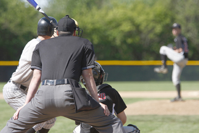 This is a picture of a baseball game, with a pitcher ready to throw a pitch towards a batter. A catcher and an umpire are positioned behind the batter.