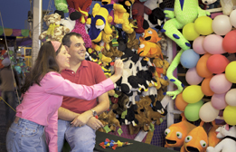 This is a photo of a woman tossing darts at balloons.