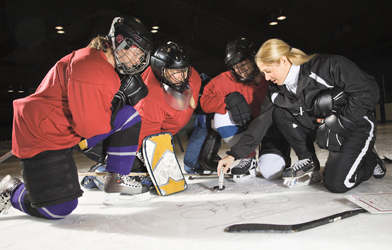 This photo shows a coach talking with a hockey team.