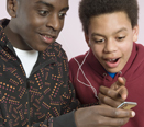 This photo shows two boys listening to an MP3 player together.