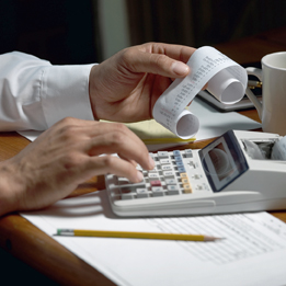 This is a photo of a person’s hands using an adding machine.
