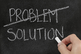 This photo is of a chalkboard. The word PROBLEM is crossed out. Underneath, the word SOLUTION is written.