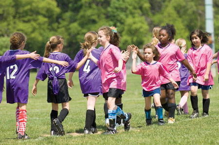 In this photograph, members of two soccer teams shake hands after a game in this photograph.