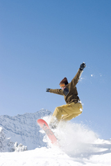 A photograph of a snowboarder in midair after taking a jump.