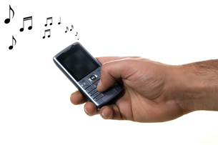 A photograph shows a hand pressing a button on cellular telephone to attend to the ringtone.