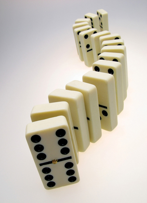 A photograph of many dominoes standing on their short edge.