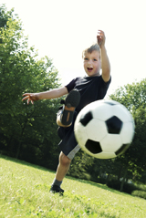 This photograph shows a young boy kicking a soccer ball. His constant high level of activity and slim body could be symptoms of hyperthyroidism.
