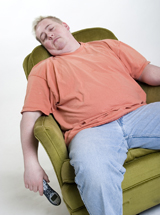 This photograph shows an overweight, middle-aged man sleeping in a chair with the TV remote in his hand. He could suffer from hypothyroidism.