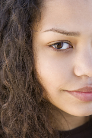 The picture shows the serious half face of a teen girl, showing only the right side of her face.