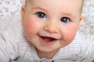 This photograph shows a smiling baby.