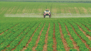Picture of a farmer driving a tractor and spraying his field