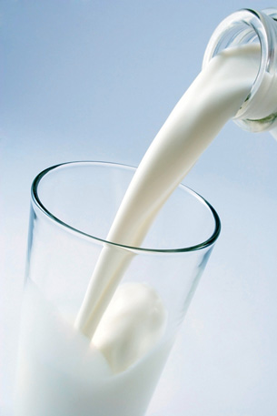 The photo shows milk being poured into a glass.
