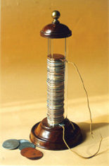 A photograph shows an early battery. The battery is formed by stacking discs made of zinc and copper in an alternating pattern. A wire is attached to the disc at the bottom of the stack, and another wire is connected to the disc at the top of the stack.