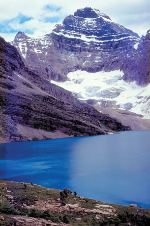 A photograph of a lake surrounded by snow-capped mountains.