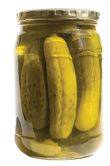 A photograph showing a glass jar containing pickled cucumbers.