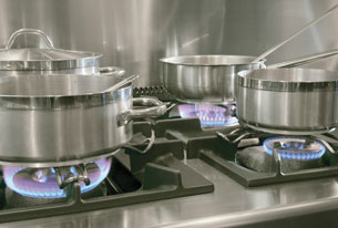 A photograph of metal cookware on a gas stove.