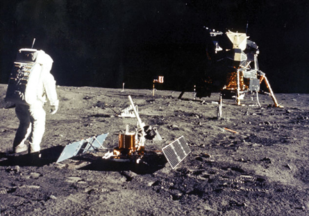 A photograph shows an astronaut in a space suit walking on the surface of the moon.  