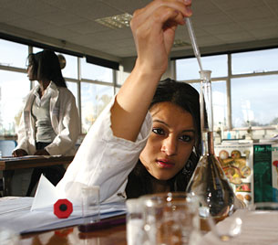 A photograph of a female student using a pipette to add the final drops of water to prepare a standardized solution.