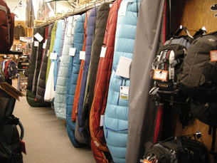 A photograph shows several sleeping bags hanging in a store.