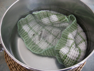 A photograph shows a pot containing boiling water. A cloth containing a hot pack is in the water.