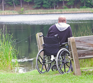 A photograph shows a man fishing from a wheelchair beside a lake.