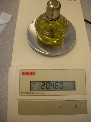 Photo 2: This photograph shows the spirit burner filled with olive oil sitting on the balance, so that the initial mass can be read.