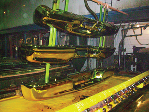 A photograph shows three car bumpers held in a rack above a vat where chromium plating occurs in a commercial electroplating operation.