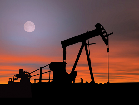A photograph shows a pumpjack at night.