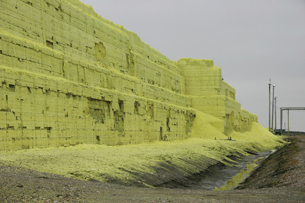 A photograph shows yellow block of sulfur that is the size of several city blocks.