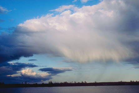 A photograph shows large rain clouds hovering over a lake.