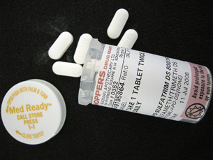 A photograph shows several white, oval-shaped antibiotic tablets and their prescription container.