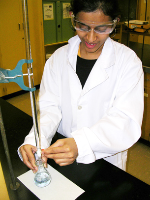A photograph shows a young woman performing a titration.