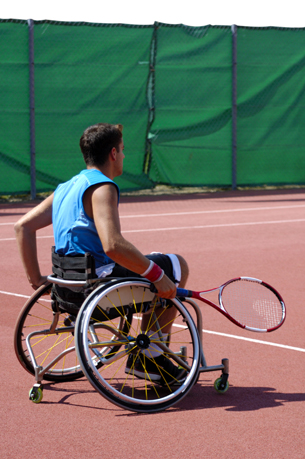 A photograph shows a man in a wheelchair playing tennis.