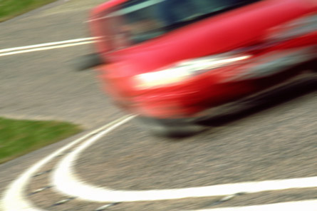 A photo shows a car negotiating a turn so quickly it is blurry.