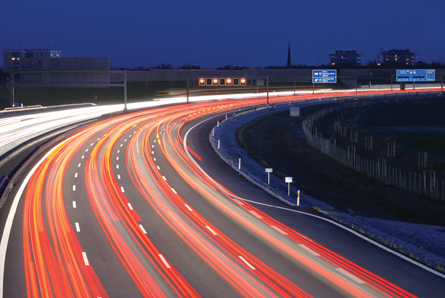 A time exposure photograph shows an eight-lane highway at night.