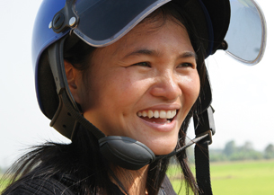 The photo shows a young woman wearing a motorcycle helmet.