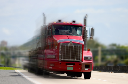 The photograph shows a speeding semi truck, which has considerable momentum.