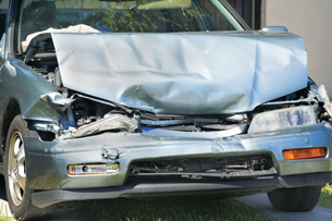 The photo shows the crumpled hood of a car that has just been in a collision.
