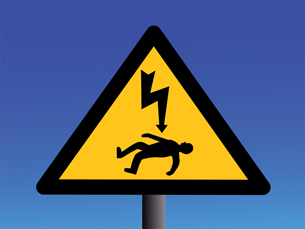 The image is a triangular warning sign that shows a man on the ground with a giant lightning bolt pointing down at him. It warns that high-voltage power lines are dangerous because they carry significant amounts of current.