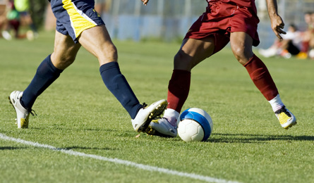 Soccer players running after the ball.