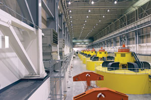 A photograph shows turbines that spin generators to convert mechanical energy into electrical energy.