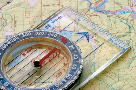 A photograph shows a compass on a map.