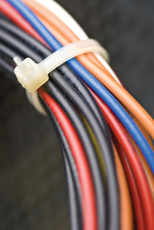 A photograph shows electrical wires bundled close together. Their magnetic fields can interact to produce attractive and repulsive forces.
