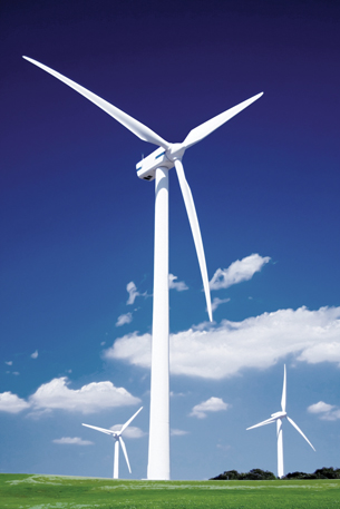 A photo shows three wind turbines against a brilliant blue sky. A wind turbine generates electric current by forcing a conductor through an external magnetic field.