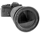 A 35 mm camera, with zoom lens fitted, is shown isolated from the background.