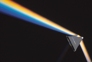 An image shows a ray of white light entering a triangular prism and refracting into a spectrum of light.