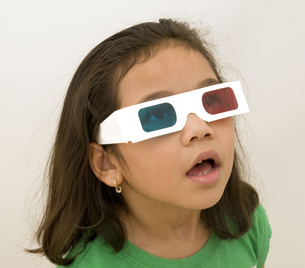 A photograph shows a girl watching a 3-D movie using blue and red filter glasses.
