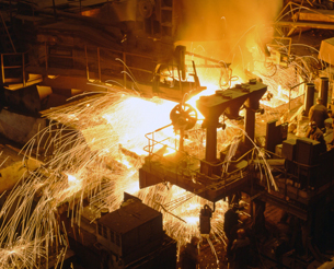 A photograph shows an iron works, with molten steel glowing. Hot molten steel emits visible light.