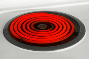 A photograph shows the glowing coils of a hot element on a stove. A stove element emits visible light at high temperatures.