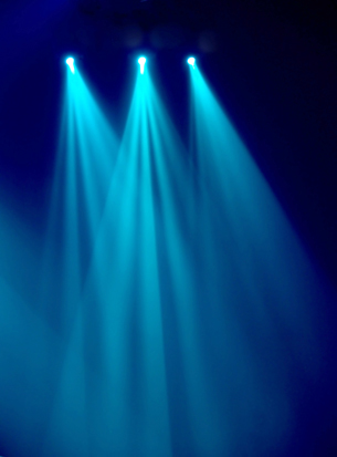 An image shows three spotlights shining through a cloud of smoke.  Are these lights releasing particles or waves or both?